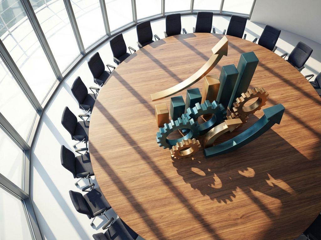 Modern boardroom with circular table featuring 3D business symbols including gears, charts, and arrows in teal and gold tones